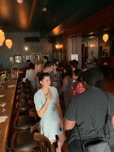 April Bethea, a Washington Post editor and DC Pro Chapter member, with back to camera, chats with another attendee at the GU SPJ happy hour event at Gaslight Tavern July 24, 2019.
